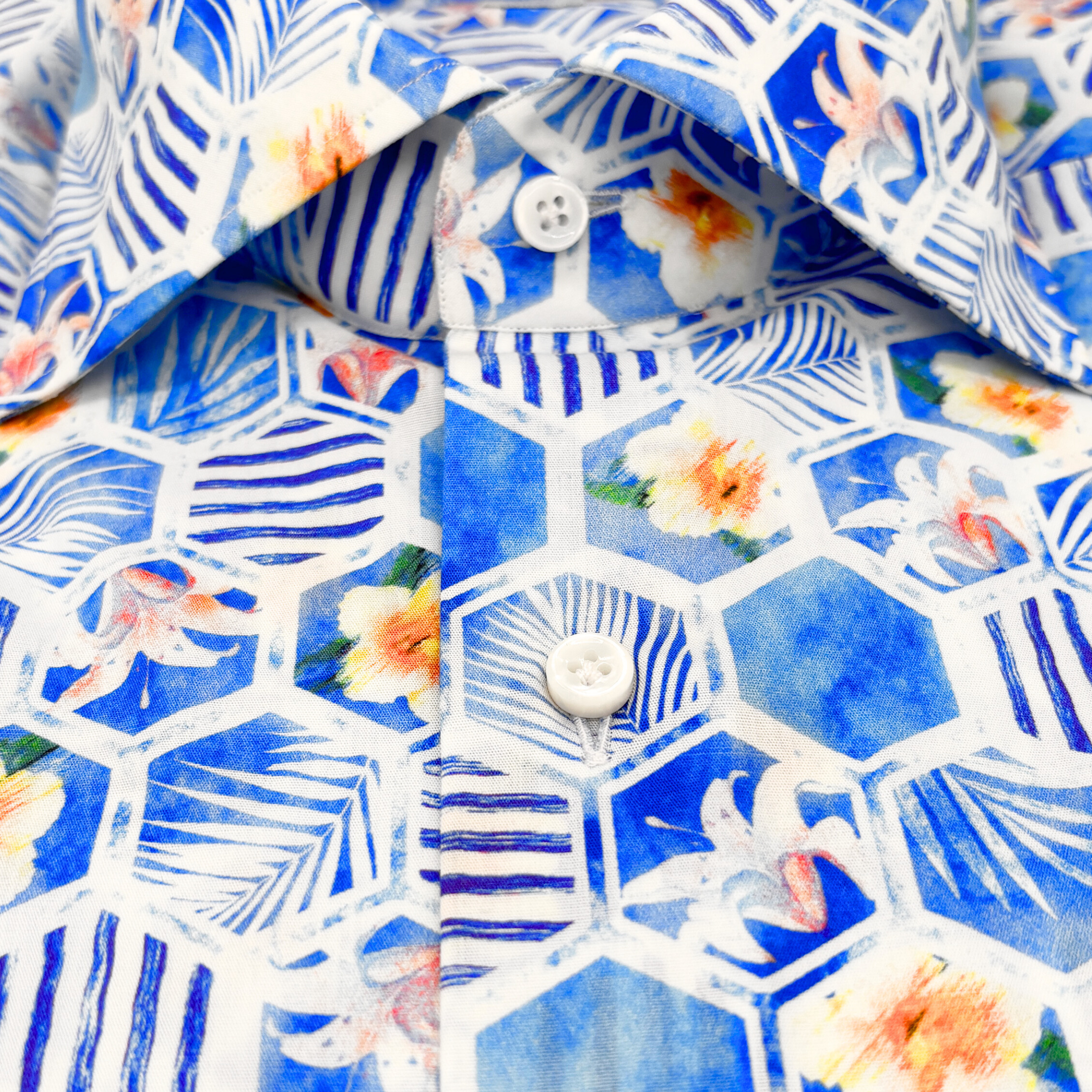 Detailansicht des Softcollar-Kragens und der runden Manschetten des nachhaltigen Herrenhemds mit blauen blumen-Muster.