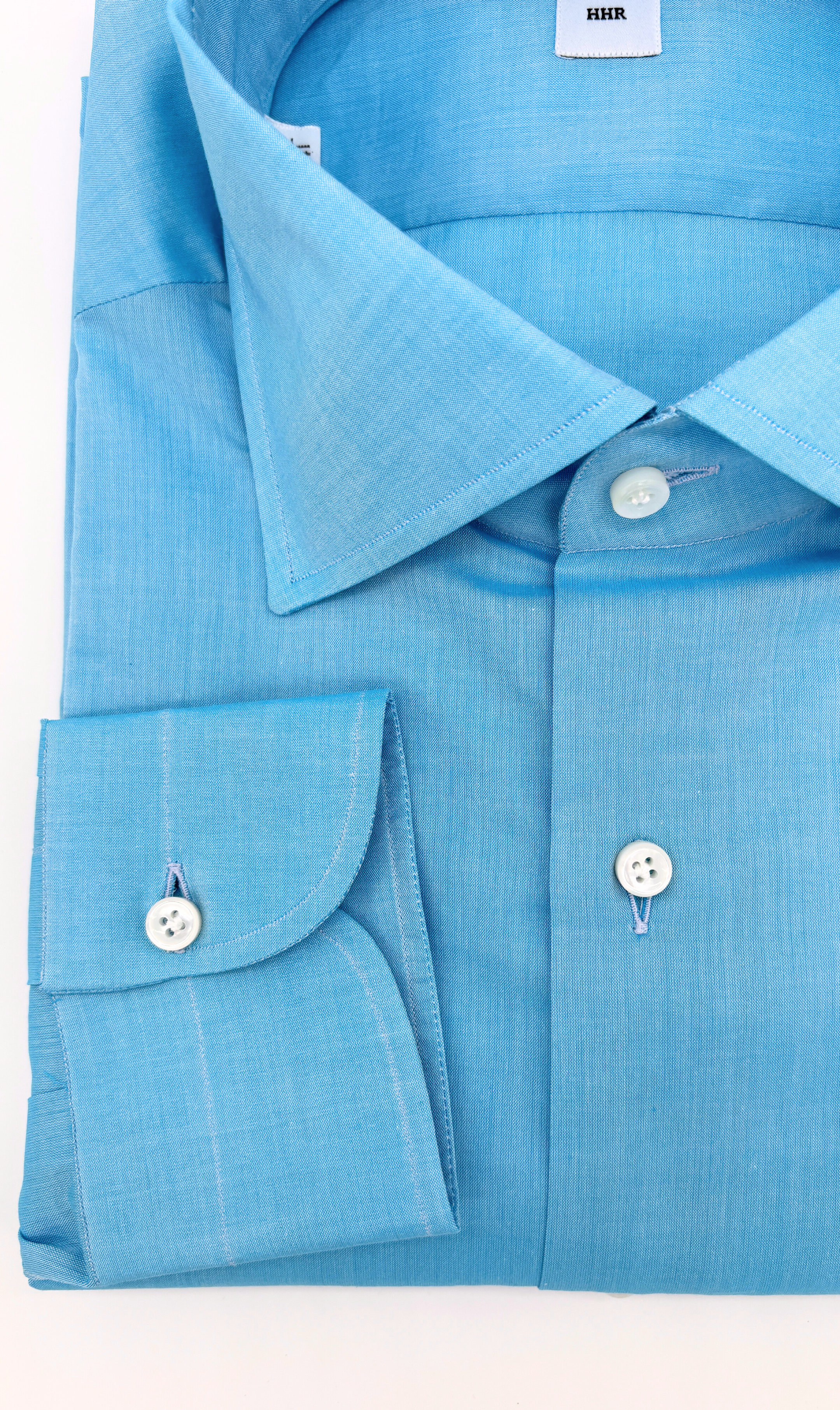 Detailansicht des Softcollar-Kragens und der runden Manschetten des nachhaltigen Herrenhemds in Blau.