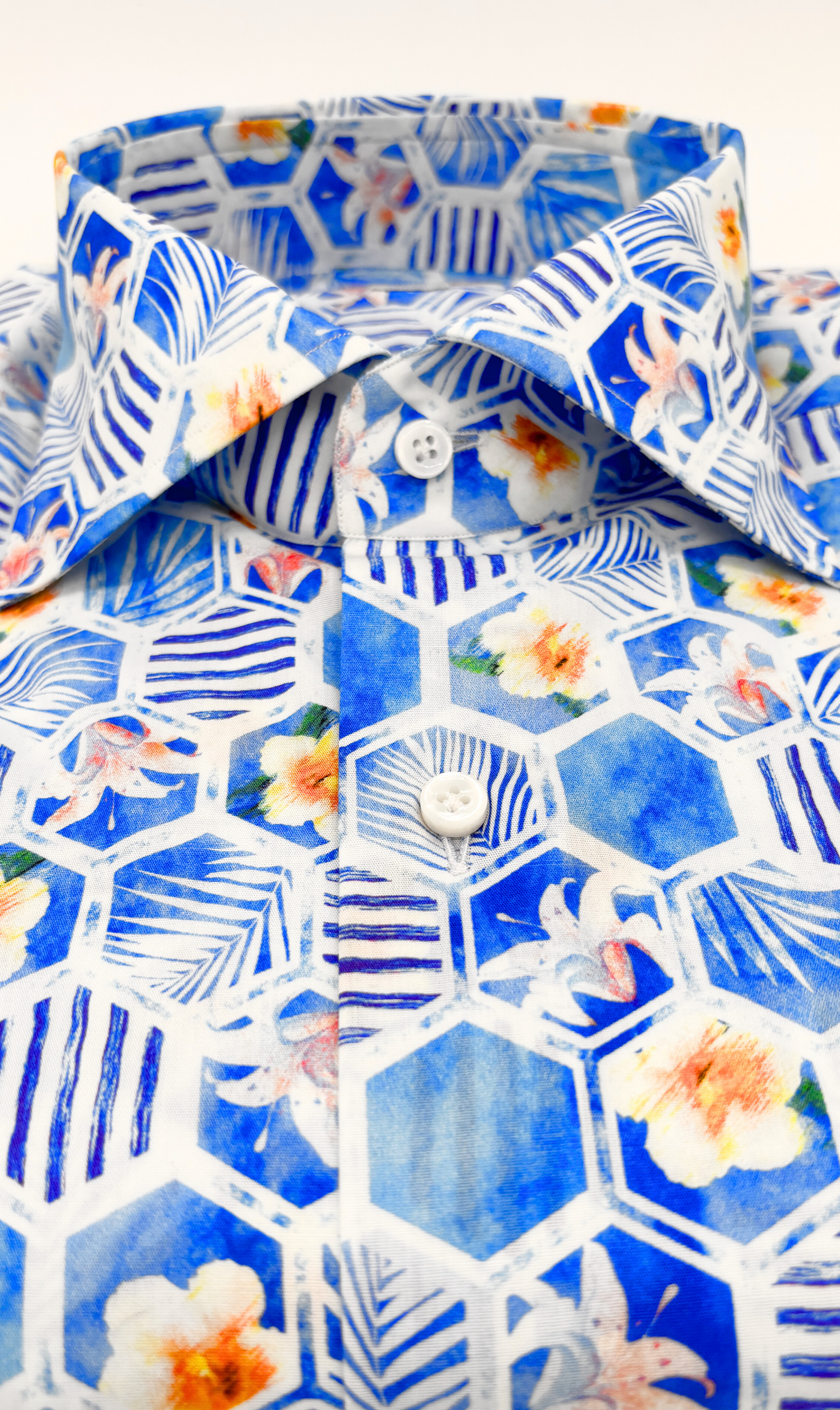 Detailansicht des Softcollar-Kragens und der runden Manschetten des nachhaltigen Herrenhemds mit blauen blumen-Muster.