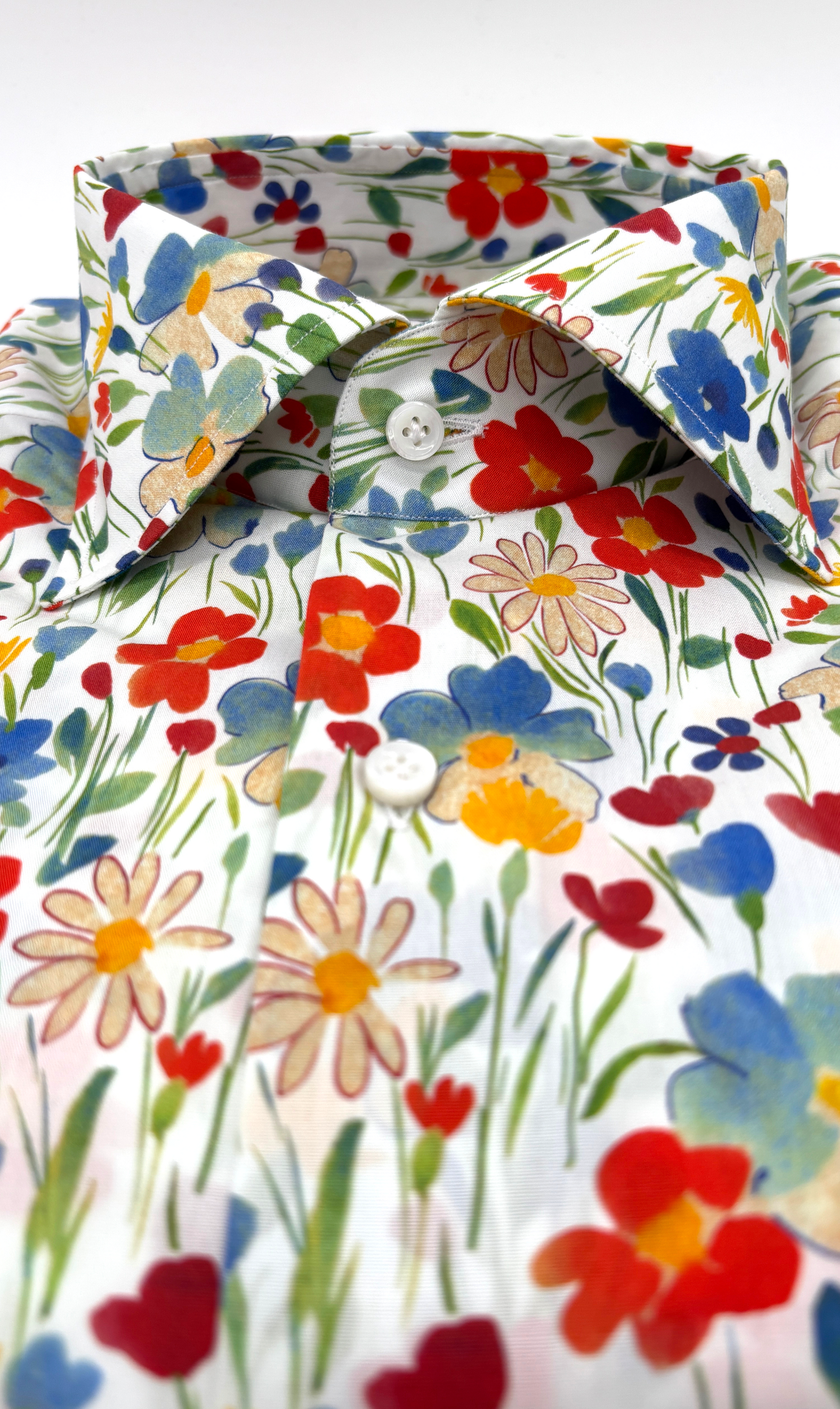 Detailansicht des Softcollar-Kragens und der runden Manschetten des nachhaltigen Herrenhemds mit bunten Blumen-Muster.
